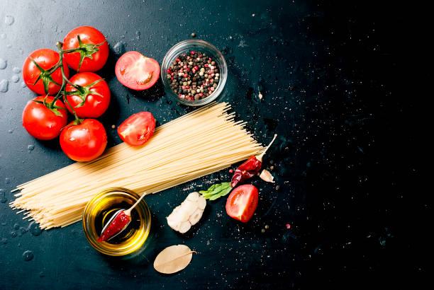 istock Black rustic tabletop with branch of tomatoes and herbs, top view 909513402