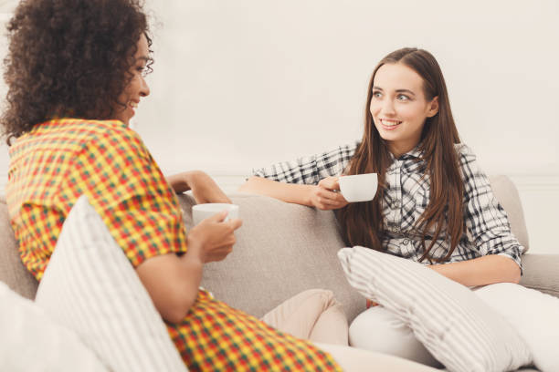 istock Two young female friends with coffee conversing 909513996