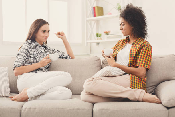 istock Two young female friends with coffee conversing 909514024