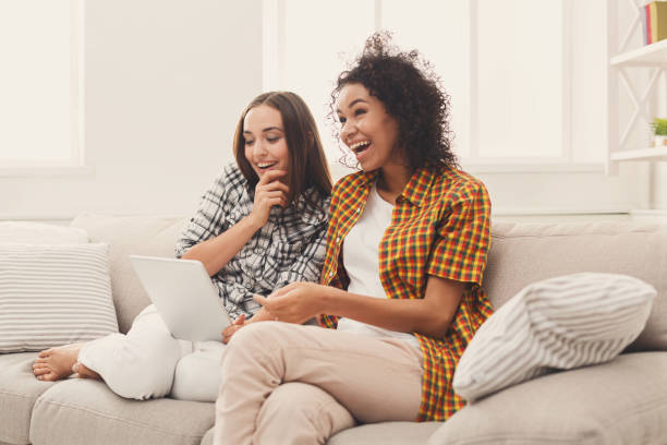 istock Two happy female friends using tablet. 909514126