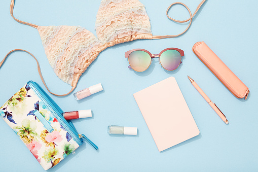 Travel, beach holiday, flat lay, bikini top, sunglasses, blue background
