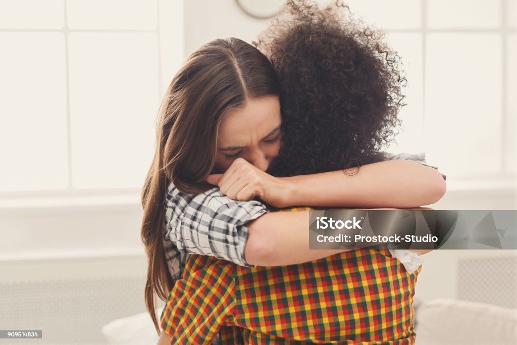 Mujer abrazando a su amiga deprimida en su casa - Foto de stock de Abrazar libre de derechos