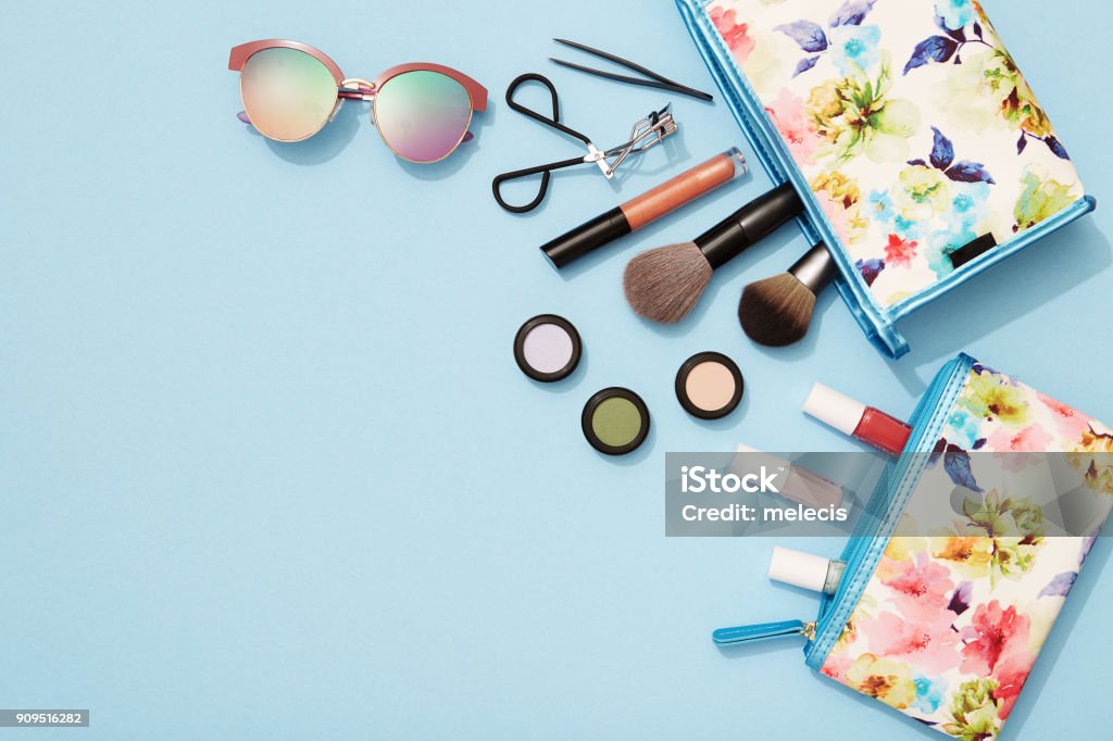 Summer makeup flat lay for beach holidays Beach holiday, make-up, flat lay, blue background, beauty product, sunglasses, Make-Up Stock Photo