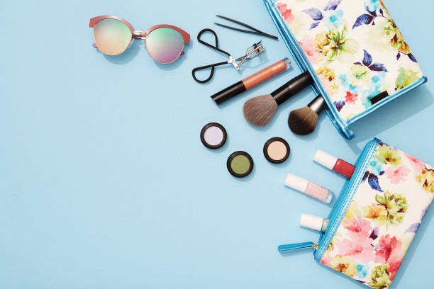 Summer makeup flat lay for beach holidays Beach holiday, make-up, flat lay, blue background, beauty product, sunglasses, make up bag stock pictures, royalty-free photos & images