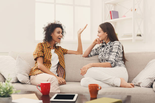 istock Two young female friends with coffee conversing 909516558