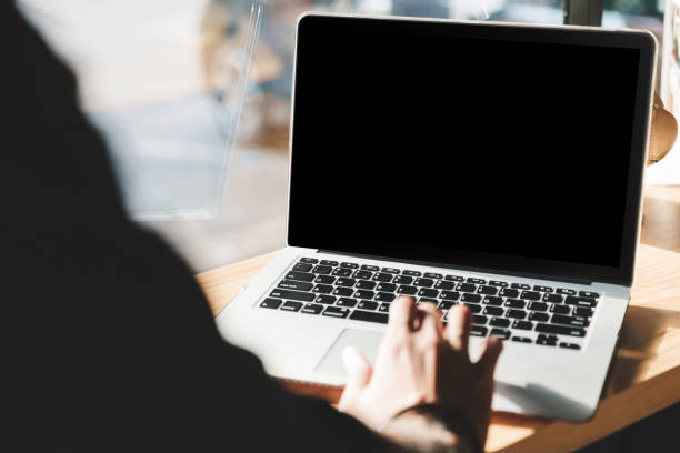 istock Man using laptop with blank screen at table in the office 909516734