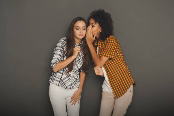 istock Young woman telling her friend some secrets 909516972