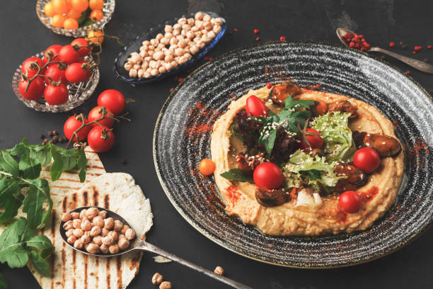 istock Hummus with vegetables and seafood on black background 909517120