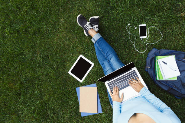 istock Girl with laptop on the grass 909518374