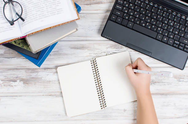 istock Workplace with laptop,  notepad, pen and books 909519190