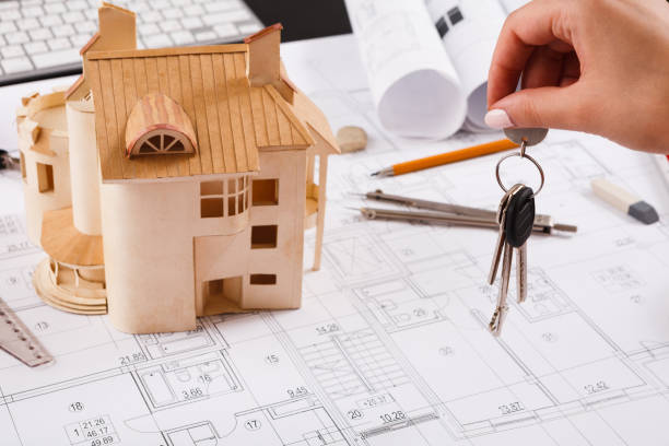 istock Architect holding keys at house model in office 909522138
