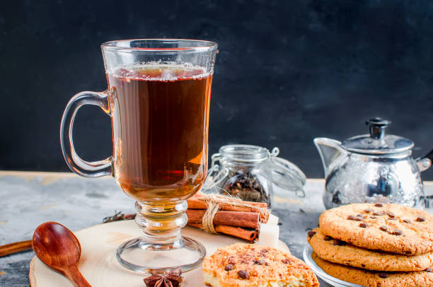istock Cup of  tea, biscuits, cinnamon, anise on dark   background 909523210