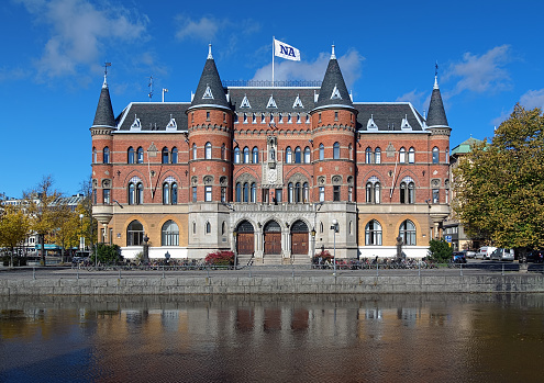 Orebro, Sweden - October 5, 2012: View of the Allehandaborgen building from Svartan river in autumn sunny day. It was originally built in 1891 for Orebro Sparbank. From 1934 to 2013 the building hosts the headquarter of the local daily newspaper Nerikes Allehanda (roughly translated \