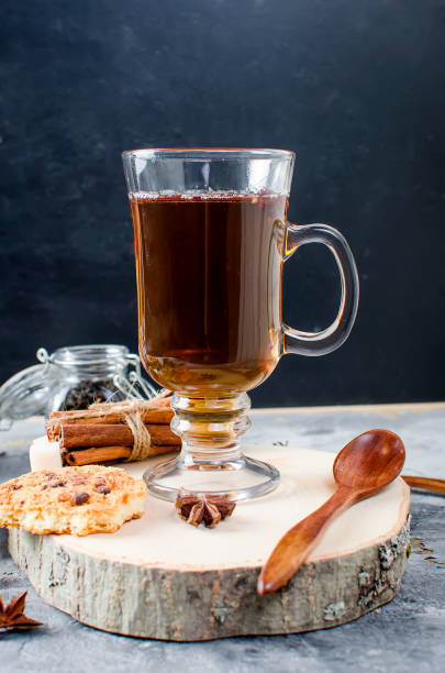istock Cup of  tea, biscuits, cinnamon, anise on dark   background 909525786
