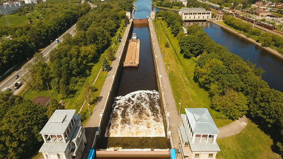 Sluice Gates on the River. Aerial view barge, ship in the river gateway. River sluice construction, water river gateway. Shipping channel.