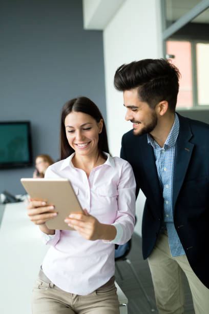 istock Happy business colleagues in modern office 909529318
