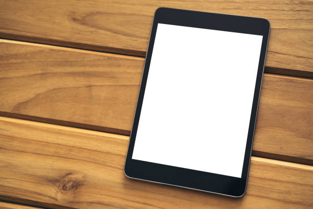 istock Mockup image of black tablet pc with blank white screen on vintage wooden table background 909529870