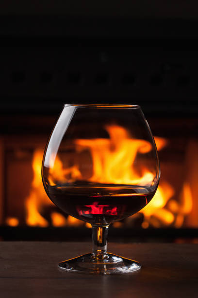istock a glass of cognac in front of fireplace 909530868