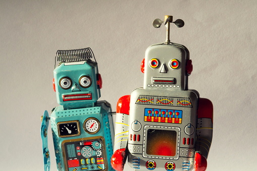 Two angry vintage tin toy robots, artificial intelligence, robotic drone delivery concept