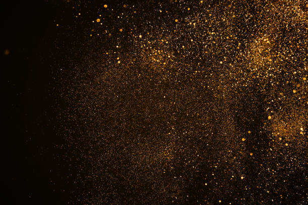 istock christmas gold sparkle glitter explosion dust particles background with bokeh, gold holiday happy new year and valentine day 909534122