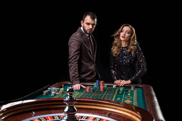 hombre con mujer jugando a la ruleta en el casino. adicción a la - couple dependency standing men fotografías e imágenes de stock