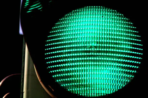 Close up view of green color on the traffic light. German street sign.