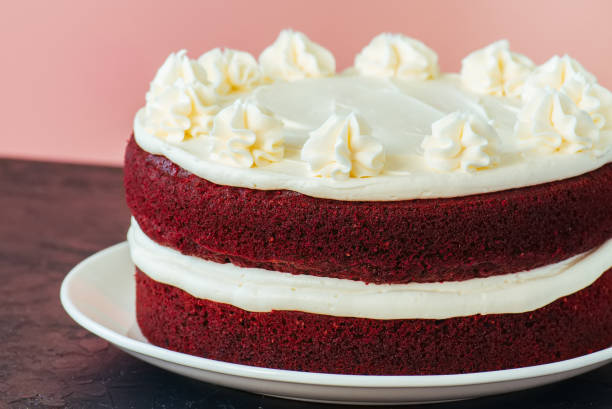 istock Red velvet cake with cream cheese frosting on a white plate 909538896