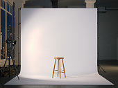 Modern photostudio with blank screen and wooden chair. 3d rendering