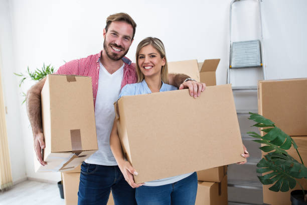 istock Young couple holding and packing boxes for moving 909546954