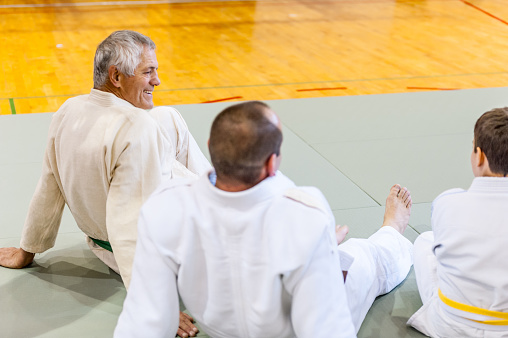 Group of people sitting and resting on judo training class.