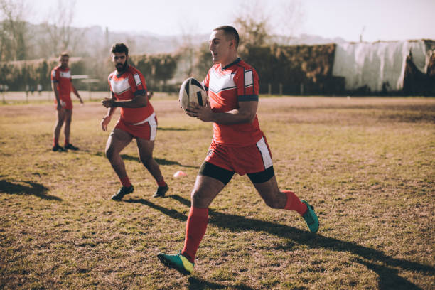 istock Passing the ball on a rugby field 909554838
