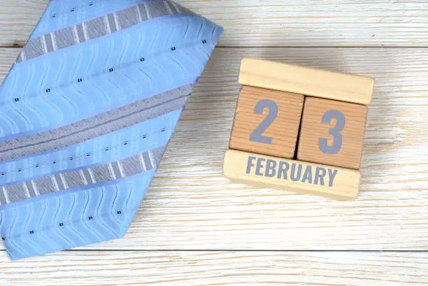 23 february calendar date on wooden blocks with blue neck tie
