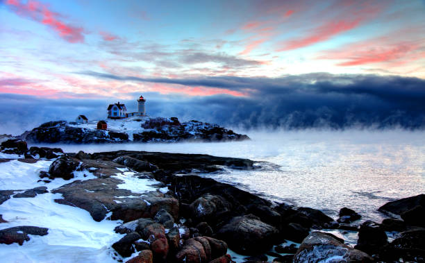 маяк нуббл в дыму арктического моря - maine lighthouse winter ice стоковые фото и изображения