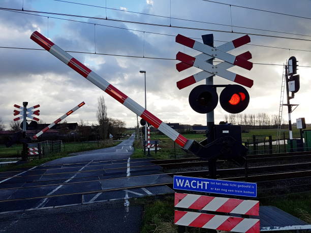 istock red light on sign and barriers while railroad is closing for coming train in the Netherlands 909569012