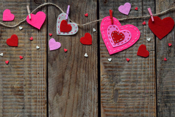 istock Valentine's Day background with handmade felt hearts, clothespins. Valentine gift making, diy hobby. Romantic, love concept. Happy lovers day greeting card mockup. Copy space. 909573038