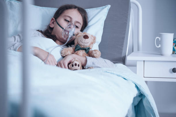 Kid with oxygen mask Kid with cystic fibrosis lying in hospital bed with oxygen mask and plush toy bronchitis stock pictures, royalty-free photos & images