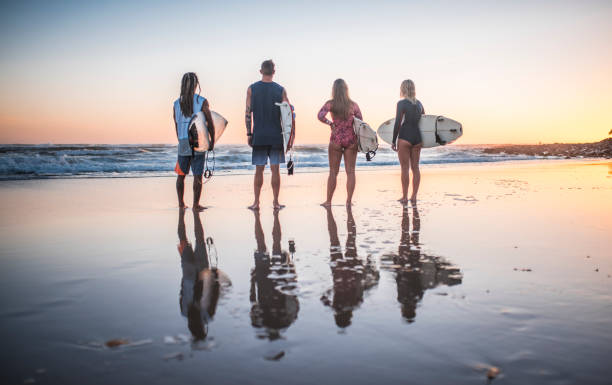 istock Young friends preparing for surfing at sunrise 909575018