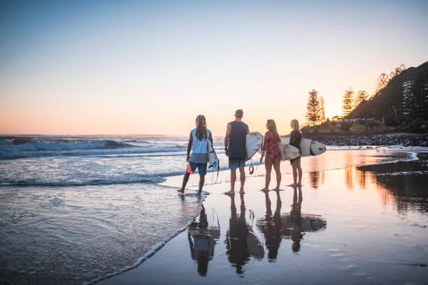 istock Young friends preparing for surfing at sunrise 909575024