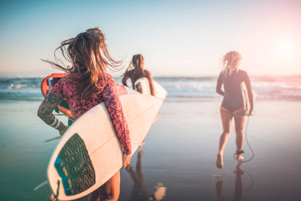 amis en cours d’exécution dans l’océan avec leurs planches de surf - horizontal men women surfboard photos et images de collection