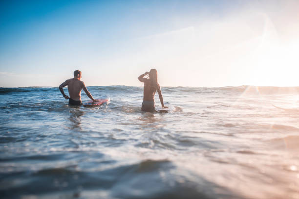 istock Young men going into the water with their surfboards 909575106