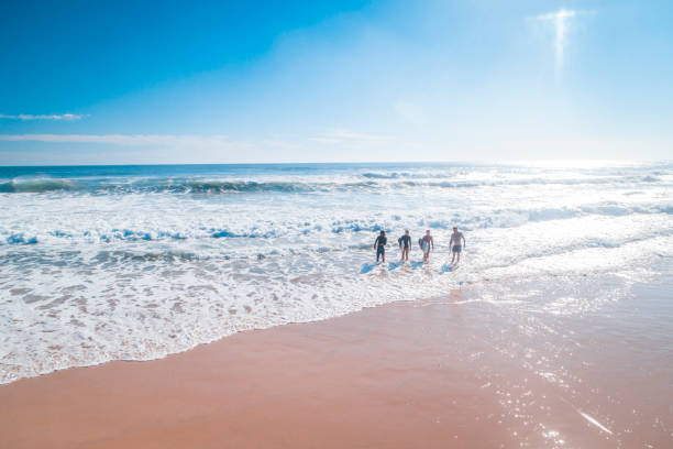 istock Surfers walking on the beach 909575222