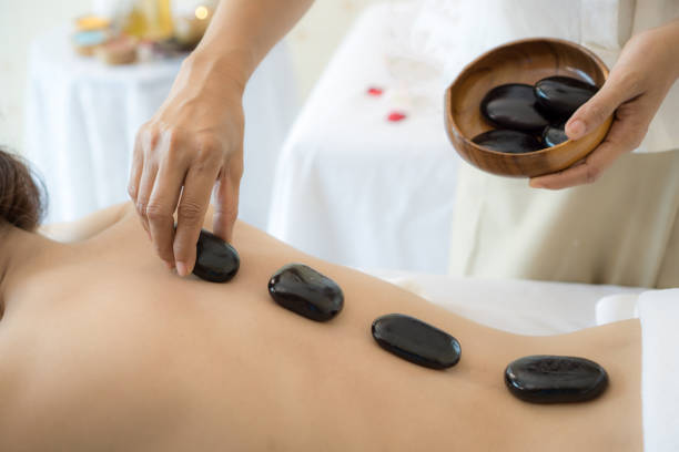 close up beautiful and healthy woman  during a back stone therapy massage in spa salon close up beautiful and healthy woman  during a back stone therapy massage in spa salon hot stone massage stock pictures, royalty-free photos & images