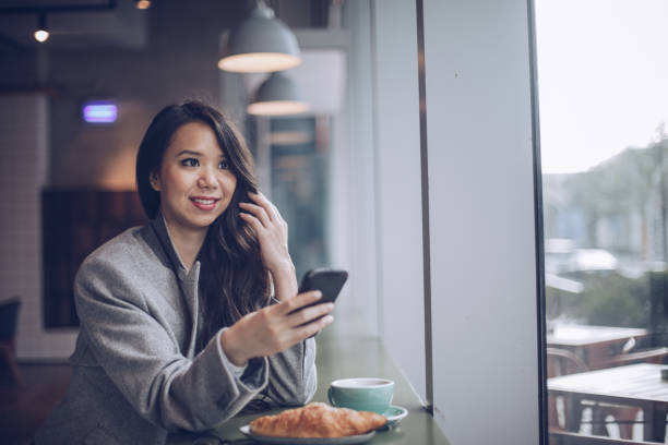 mensajes de texto de mujer mientras tener el desayuno en cafetería - croissant telephone coffee shop on the phone fotografías e imágenes de stock
