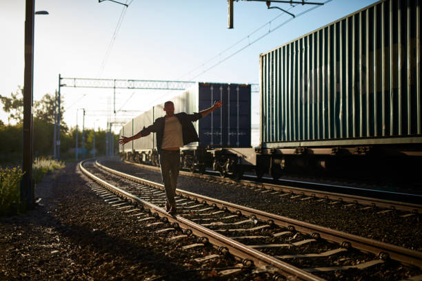 istock Young man walking on the railway. Keeping balance. Rock and roll style. 909606078