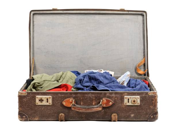 istock Old suitcase full of clothes isolated on white background 909606330