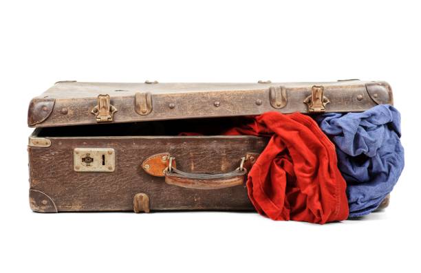 Antigua maleta llena de ropa aislado en fondo blanco - foto de stock