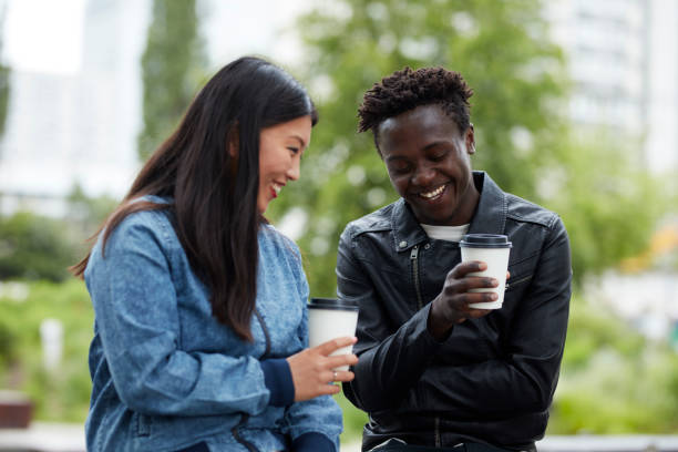 istock Multi ethnic couple on a date. Drinking coffee in the park 909606606