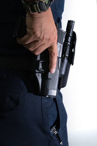 istock Carrying pistol weapon in holster at hip belt 909609444