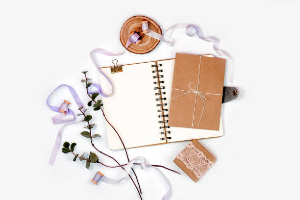 istock Bright composition with a spiral notebook, eucalyptus, silk ribbons and kraft paper on a white background. Photos for social media, blogs and web sites. Flat lay, top view, copy space 909610750