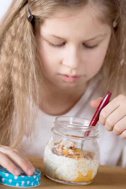 Child eating healthy - fruit, nuts and lactose free tapiolca dessert